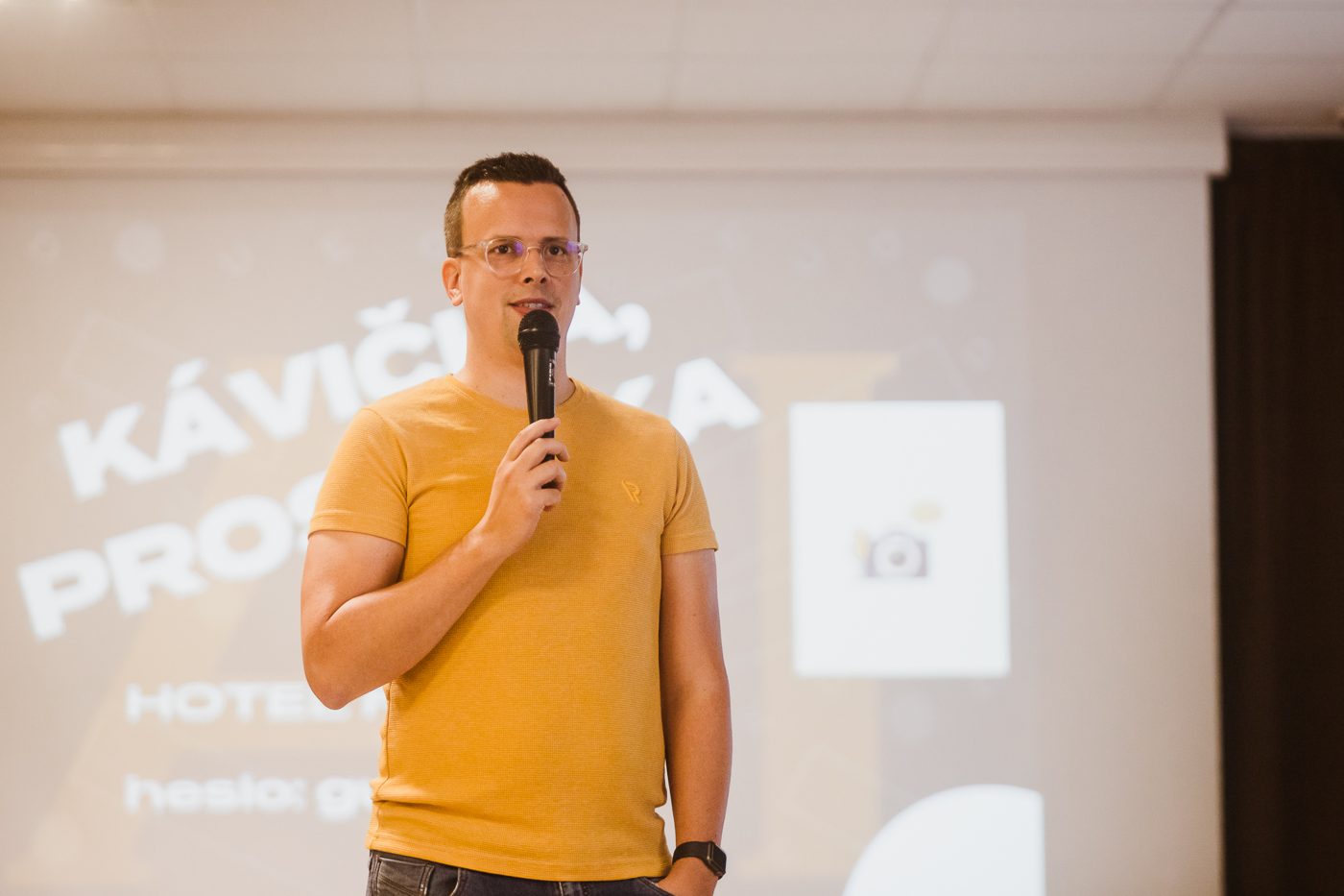 Peter Hric prednáša s mikrofónom